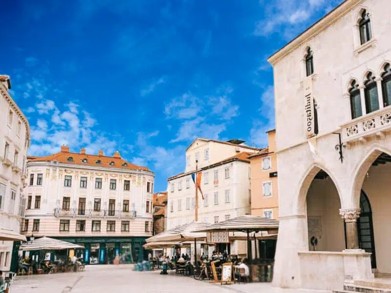 Charming square with historic buildings and clear skies.