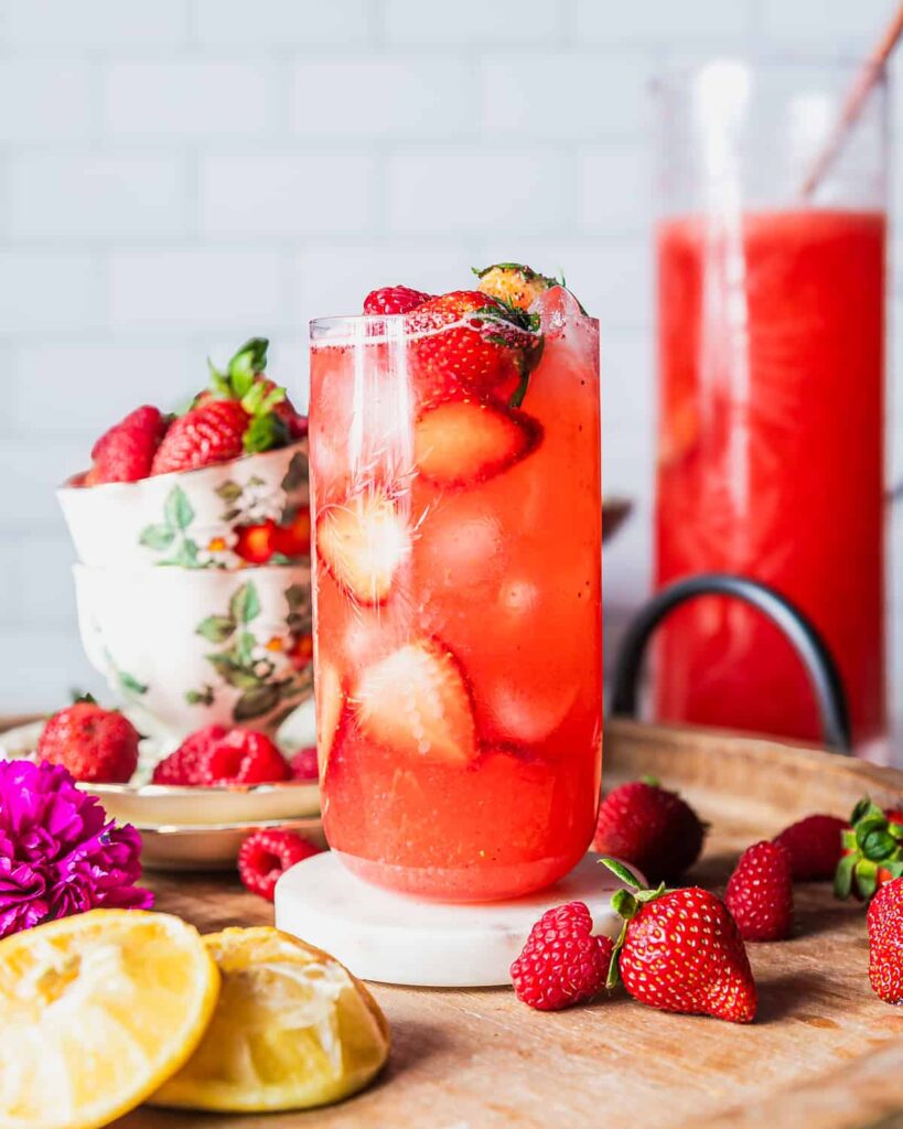 Refreshing strawberry drink with ice and fruit.