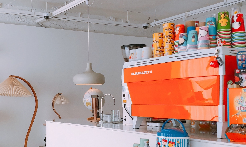 Colorful coffee machine with decorative cups.