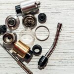 Disassembled vape components on a wooden surface.