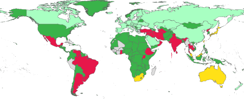 Mapa świata z zaznaczonymi krajami, w których obowiązują różne przepisy dotyczące e-papierosów, symbolizująca konieczność sprawdzenia prawa lokalnego przed podróżą.