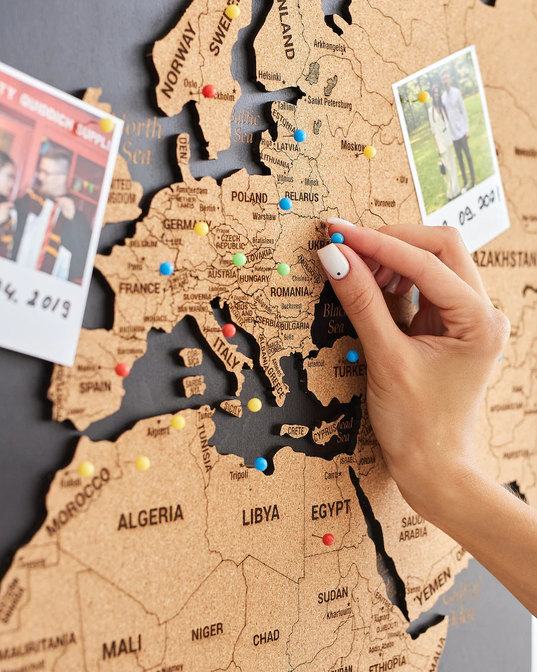 Ekran smartfona z aplikacją map, na której widnieje wiele czerwonych pinezek oznaczających lokalizacje sklepów.