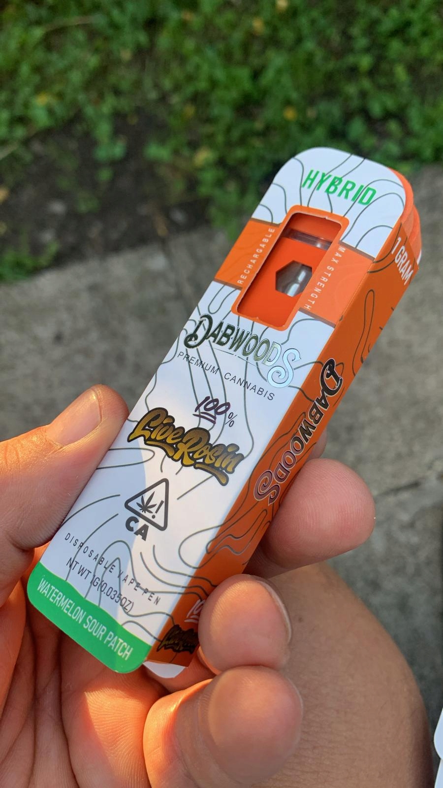 Elegancki vape pen w dłoni, na tle notatnika i filiżanki kawy.