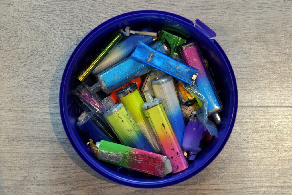 Colorful lighters in a blue container.