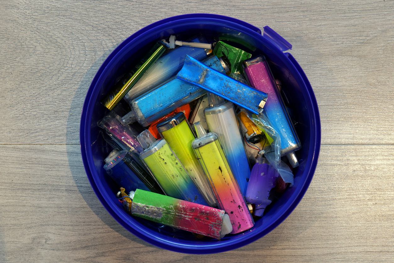 Colorful lighters in a blue container.