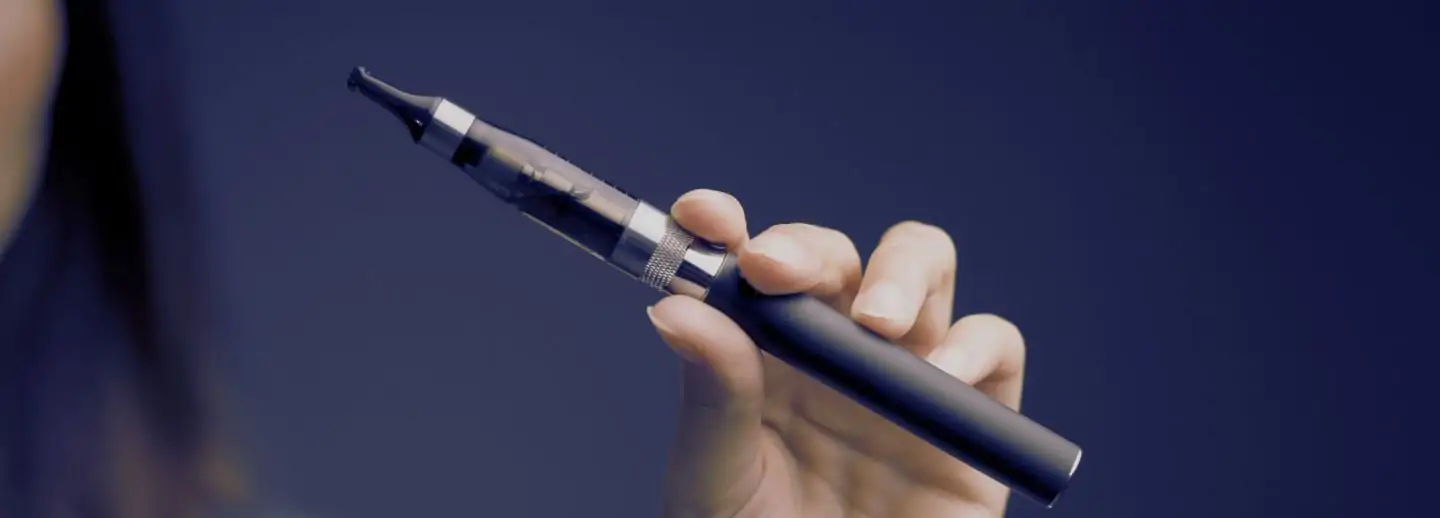 Ręka sprzedawcy prosi o dowód osobisty, a klient pokazuje go przy zakupie e-papierosa, symbolizując weryfikację wieku 18+.