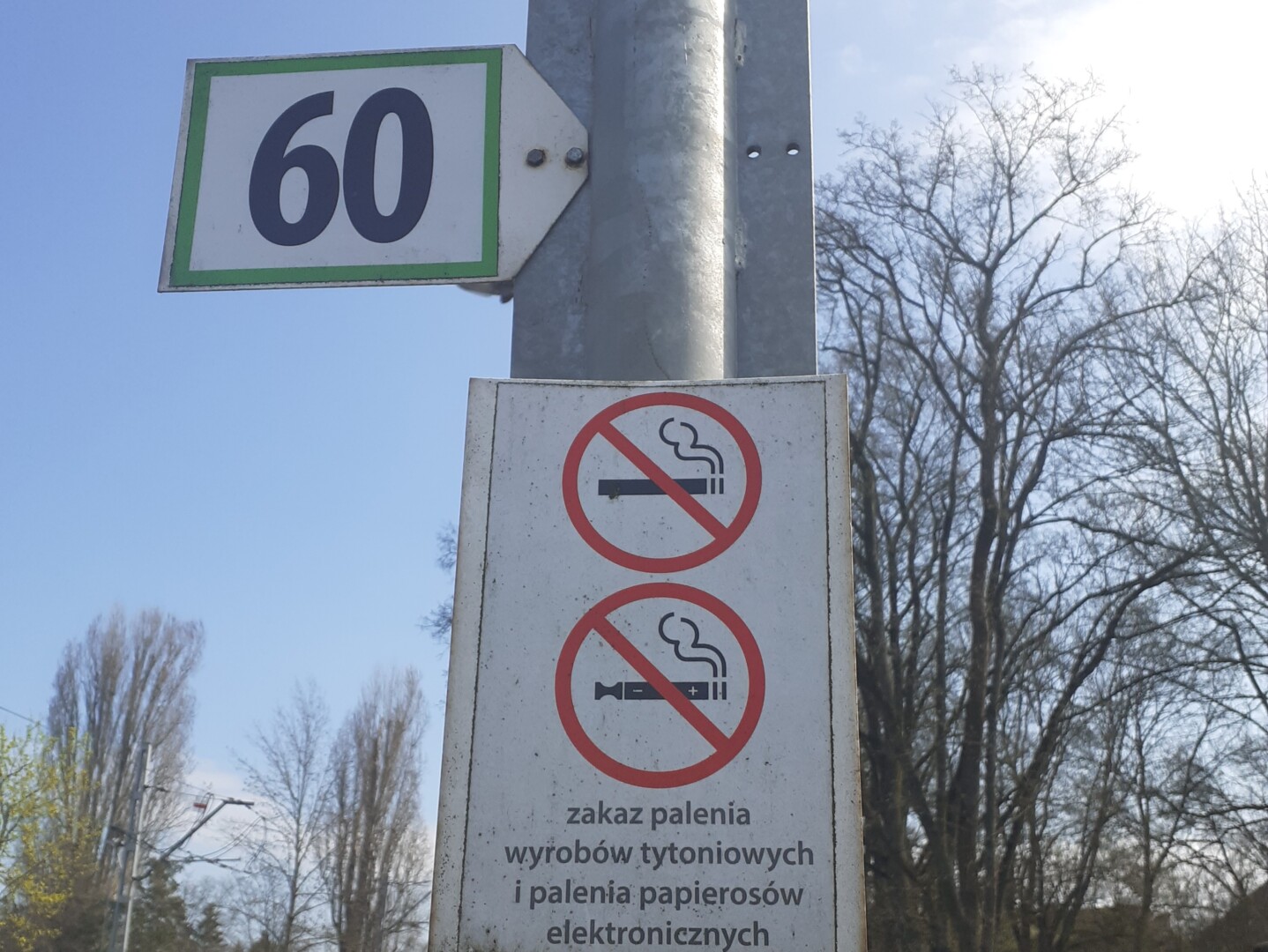 Osoba vapująca e-papierosa w centrum polskiego miasta, do której zbliżają się funkcjonariusze Straży Miejskiej.