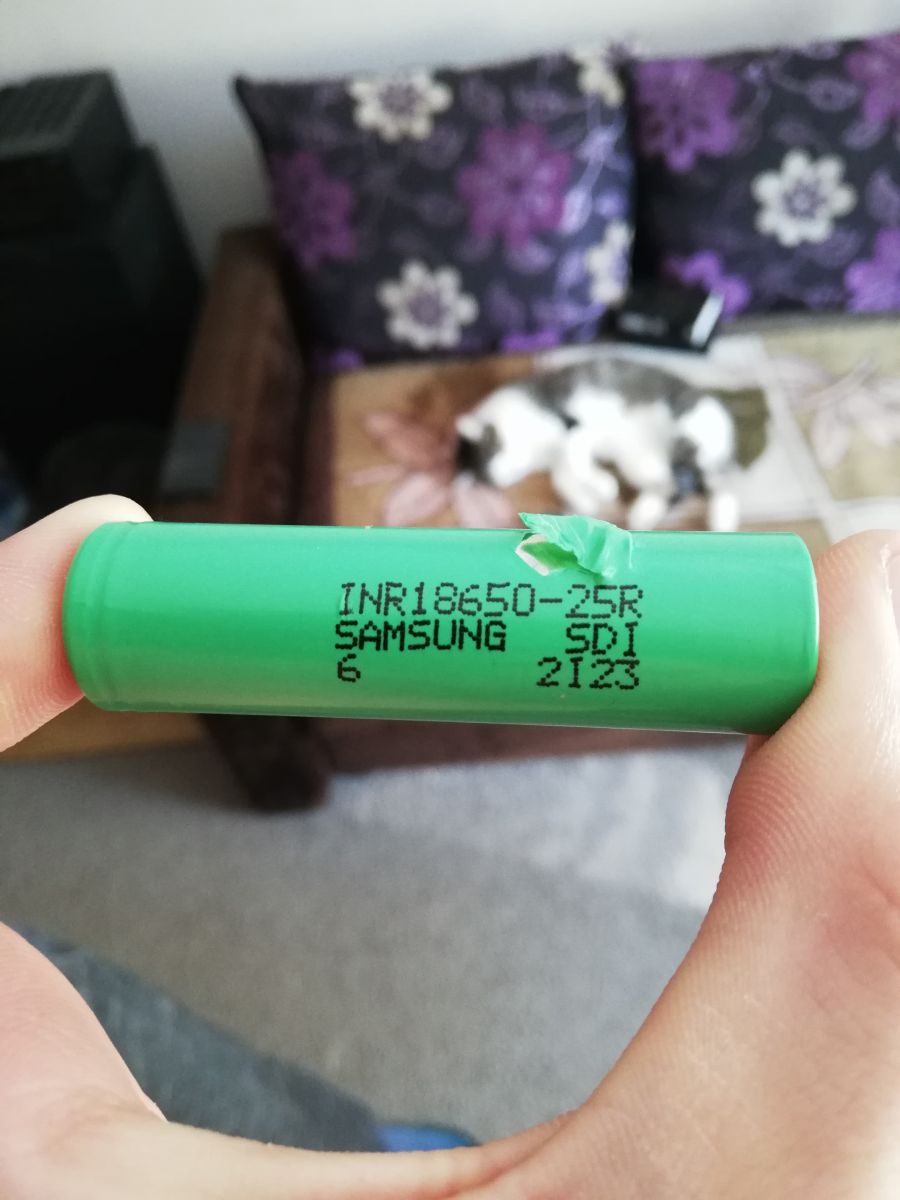 Zbliżenie na eksplodującą lub dymiącą baterię wewnątrz jednorazowego e-papierosa, symbolizujące ryzyko używania podróbek z wadliwymi ogniwami.