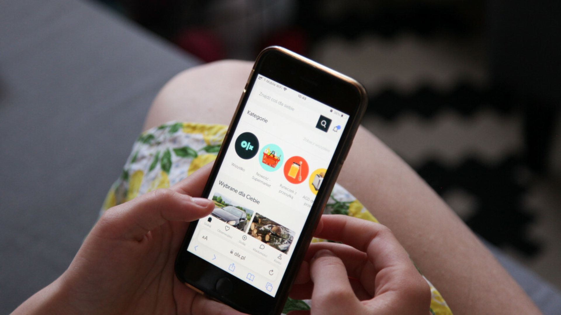 Osoba z uśmiechem przeglądająca oferty e-papierosów na telefonie (np. Allegro, OLX, Facebook), w tle zamazane ikony platform sprzedażowych.