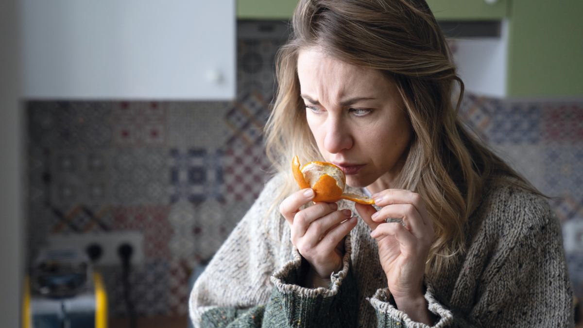 Osoba delektująca się filiżanką kawy lub jedzeniem, z wyrazem zadowolenia, symbolizująca odzyskanie zmysłów smaku i węchu po zmianie nawyków.