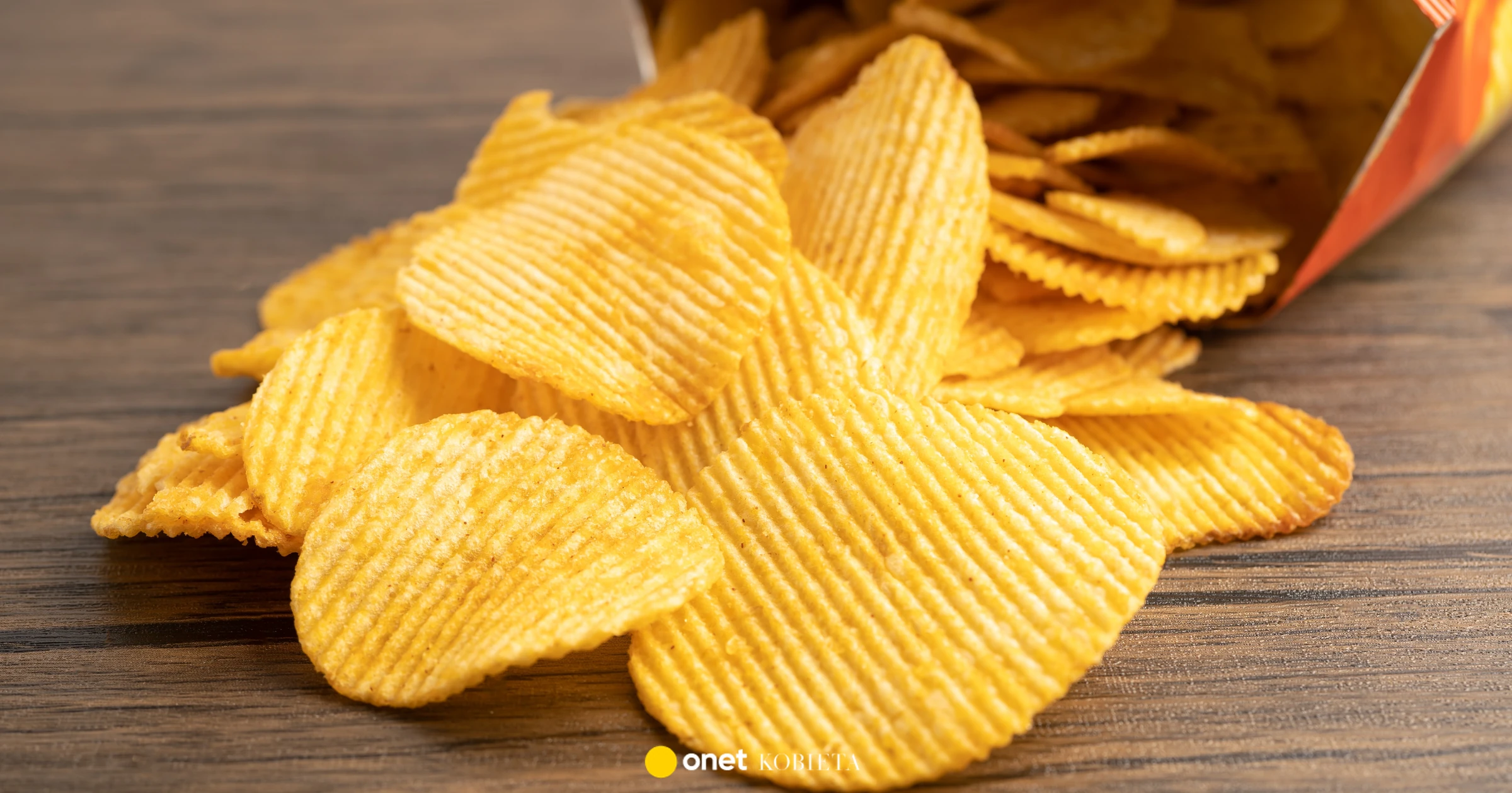 Paczka chrupiących chipsów ziemniaczanych obok artykułu naukowego lub schematu mózgu, ilustrująca analogię między uzależniającymi produktami spożywczymi a mechanizmami aktywacji układu nagrody.